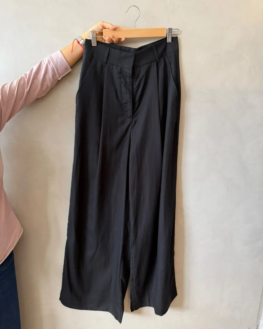Pantalón sastrero negro colgado en una percha
