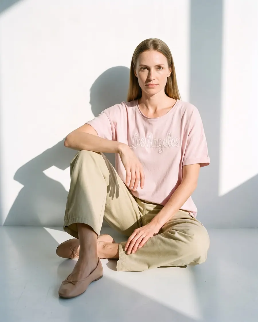 Modelo virtual con remera rosa bordada y pantalón cargo, foto 3 de 4